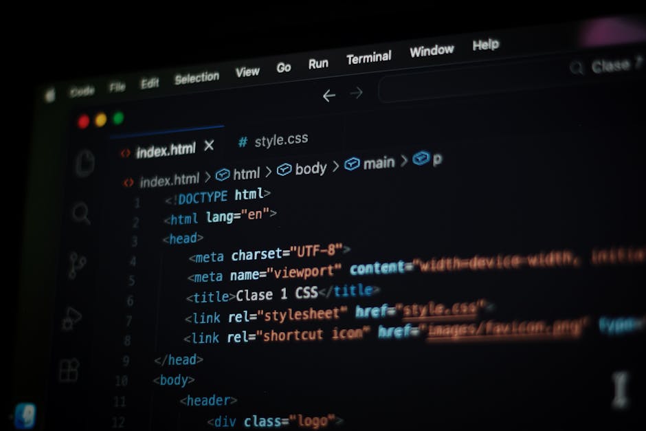 A close-up view of a person's hands working on a laptop computer placed on a dark surface. The laptop screen displays lines of colorful code, suggesting programming or software development activities.